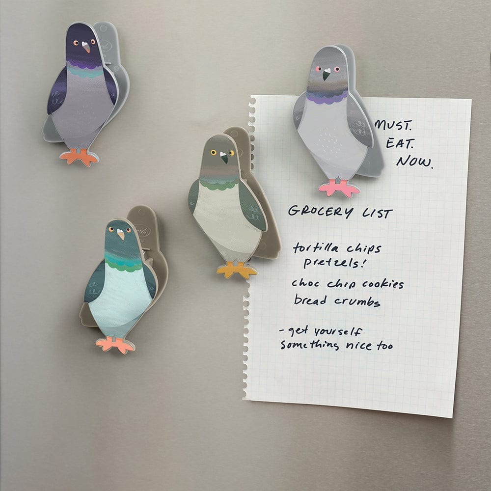 A set of four magnetic bag clips that look like pigeons placed on a refrigerator and holding up a grocery list.