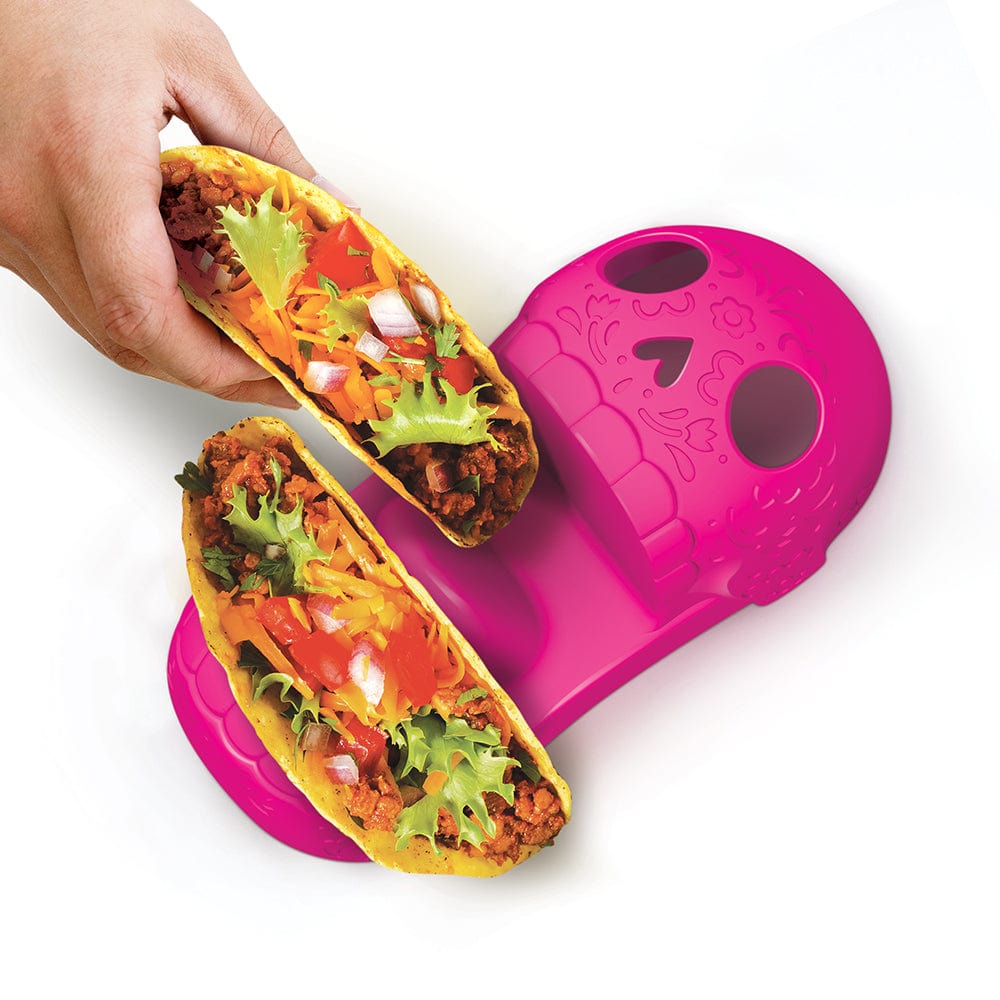 A pink  Calavera-style skull taco tray holding two hard shell tacos