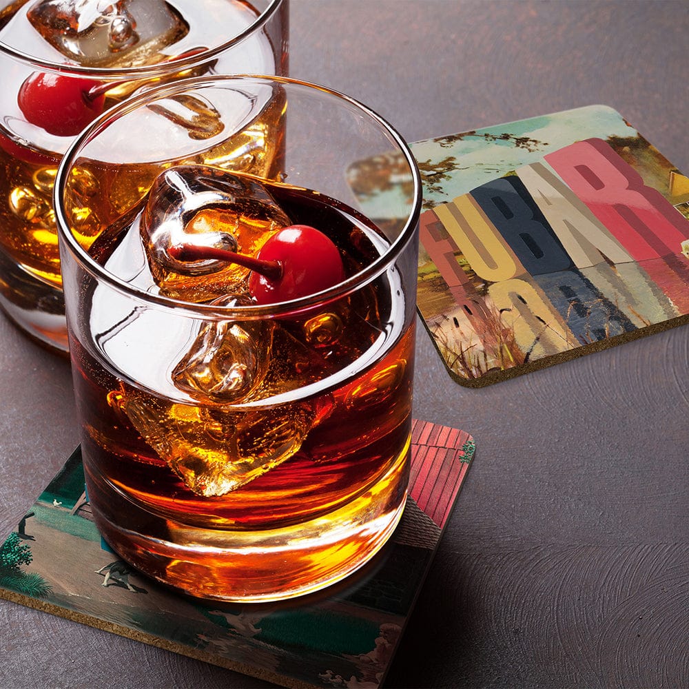 A whiskey drink with a cherry on top of coasters with art by Wayne White